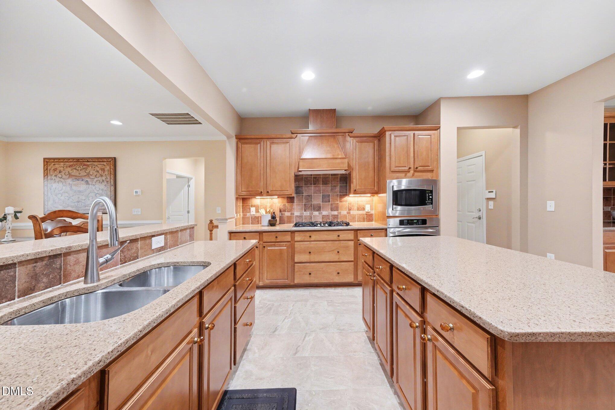 281 Beckingham Loop Cary, NC 27519 - Photo 15 of 56 a kitchen with stainless steel appliances granite countertop sink wooden cabinets and refrigerator