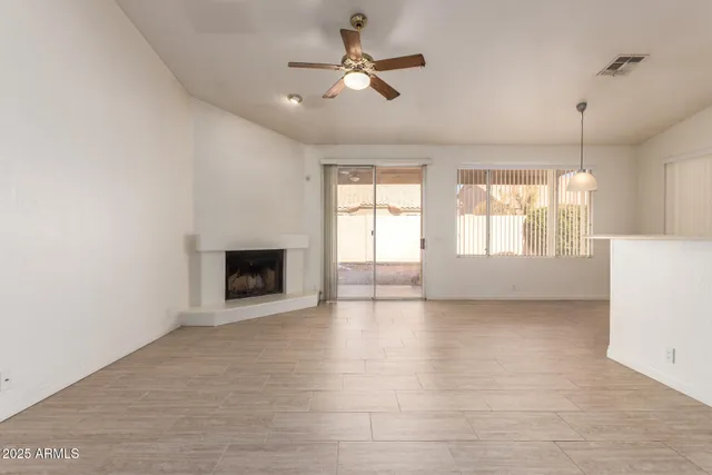 a view of an empty room with a fireplace and a window