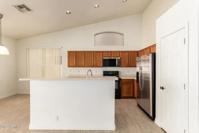 a kitchen with stainless steel appliances a refrigerator and a stove top oven
