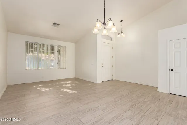 an empty room with chandelier fan