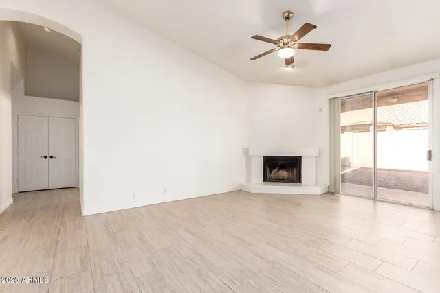 a view of an empty room with a fireplace and a window