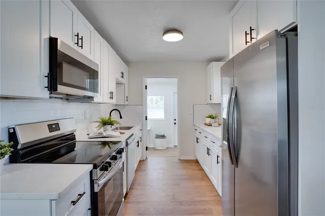a kitchen with stainless steel appliances a refrigerator sink and stove top oven