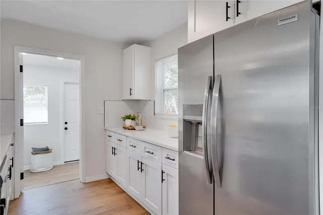 a kitchen with cabinets and a refrigerator