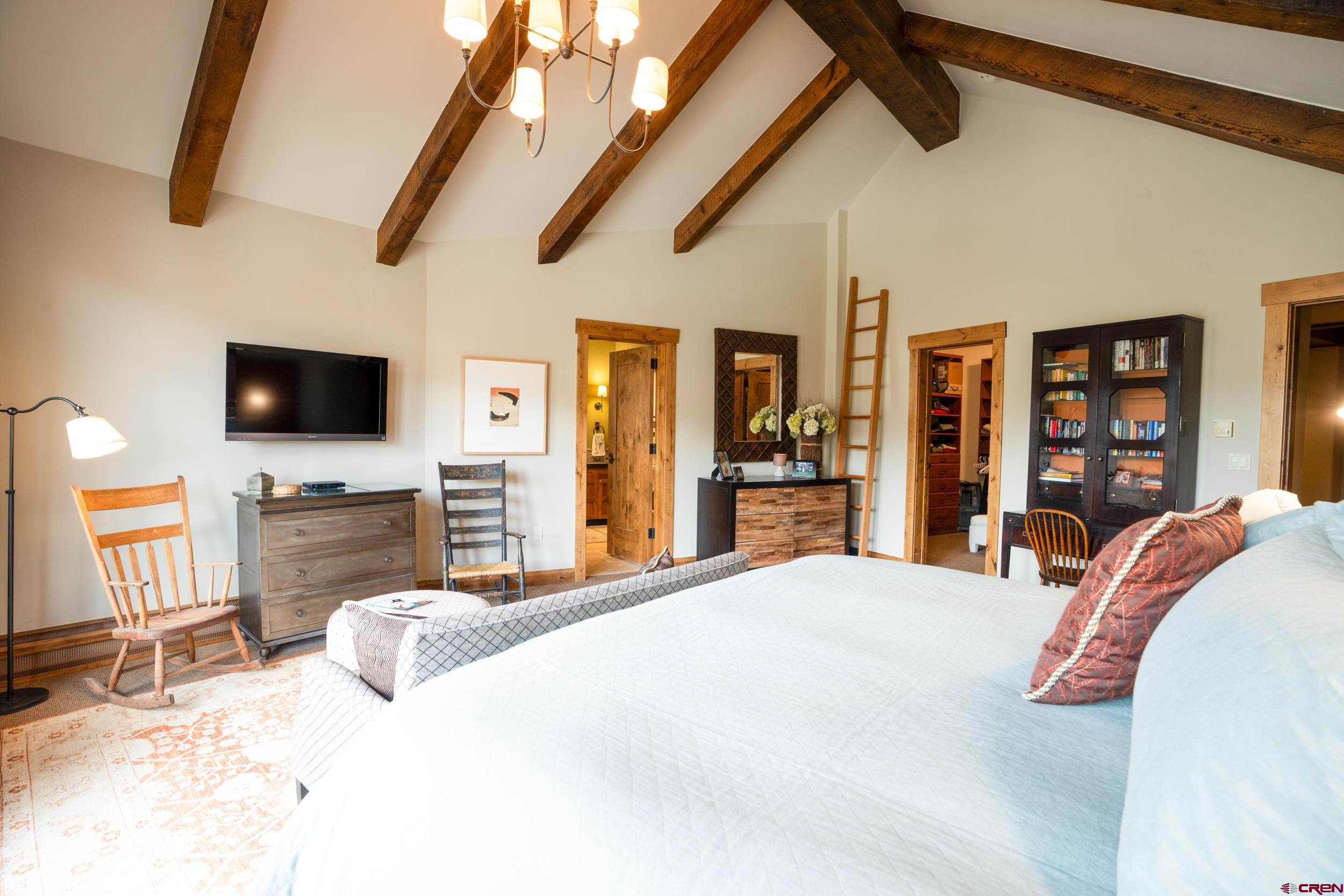 14 Hunter Hill Road, Unit A405 Crested Butte, CO 81225 - Photo 15 of 38 a bedroom with a large bed a flat tv screen and a walk in closet