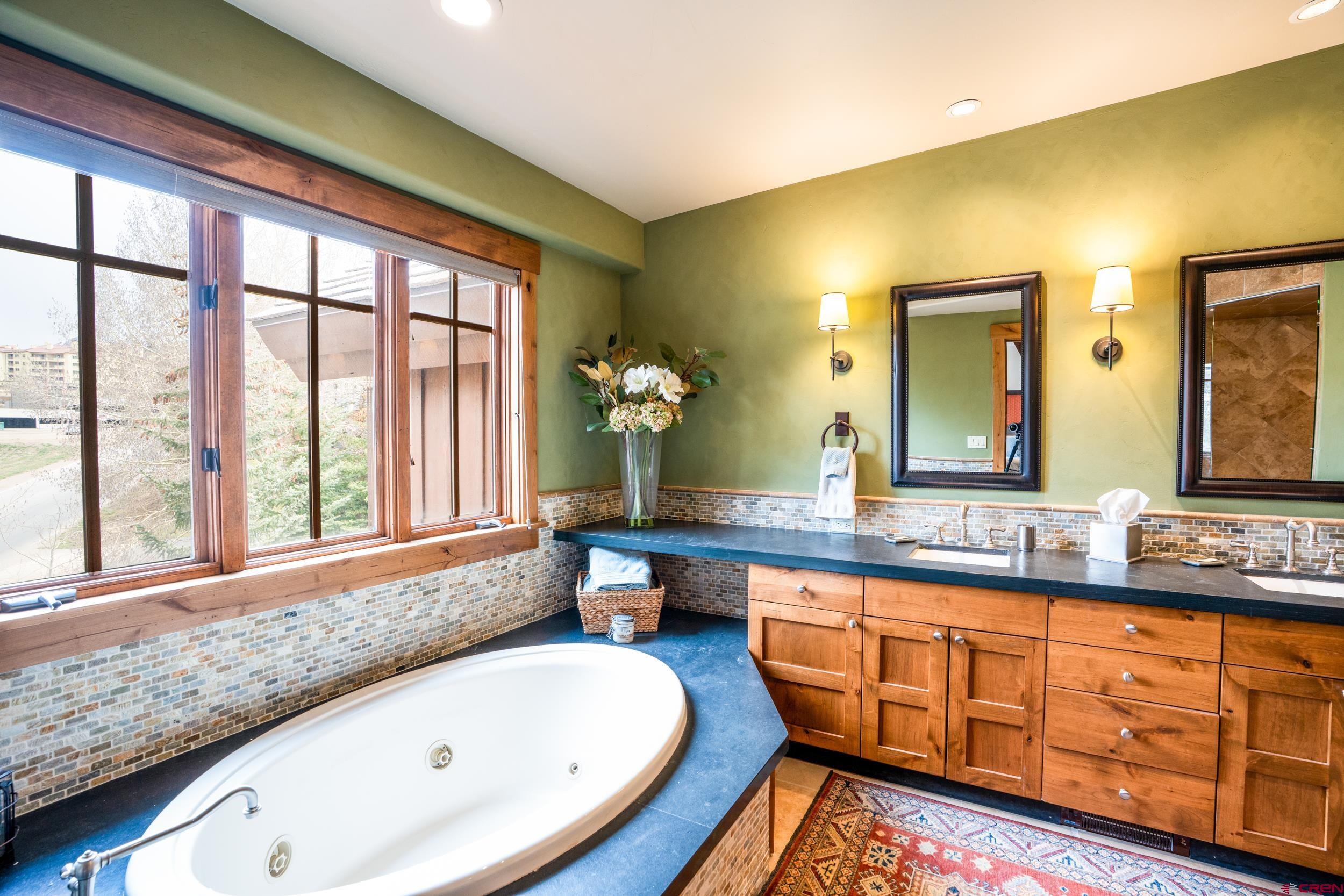 14 Hunter Hill Road, Unit A405 Crested Butte, CO 81225 - Photo 16 of 38 a bathroom with a granite countertop tub sink and mirror