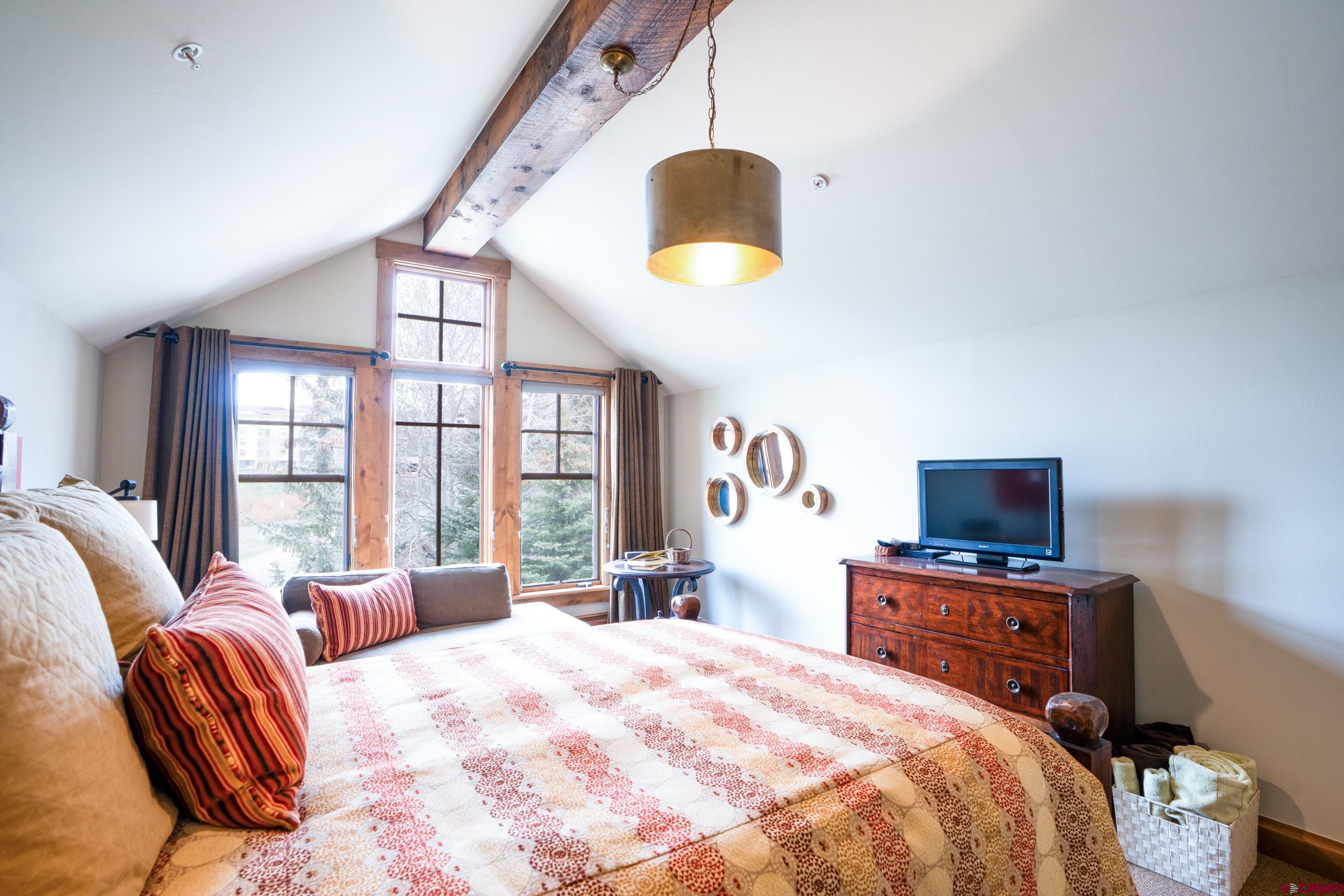 14 Hunter Hill Road, Unit A405 Crested Butte, CO 81225 - Photo 18 of 38 a bedroom with a bed and a chandelier