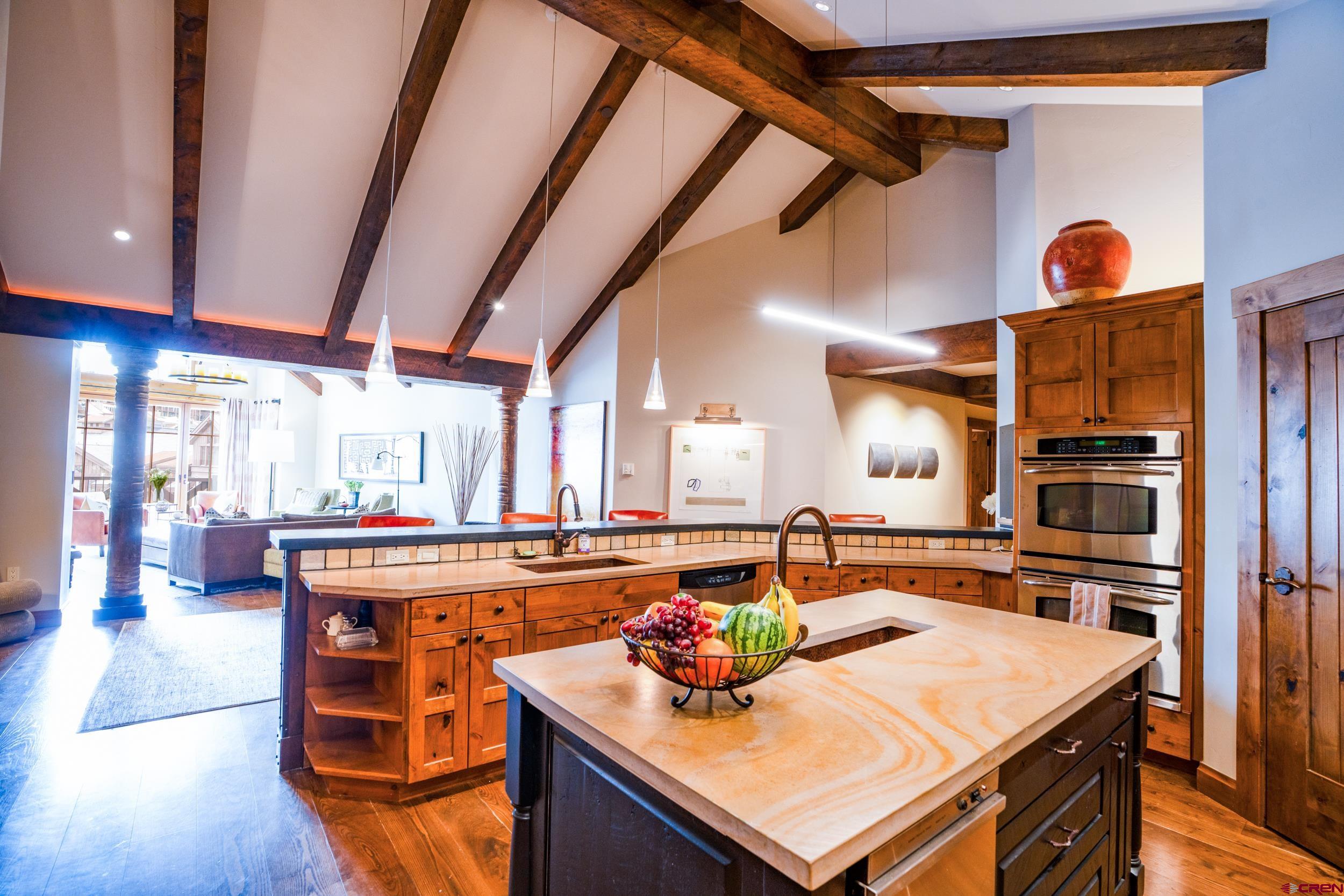 14 Hunter Hill Road, Unit A405 Crested Butte, CO 81225 - Photo 8 of 38 a kitchen with a stove a refrigerator and a dining table with wooden floor