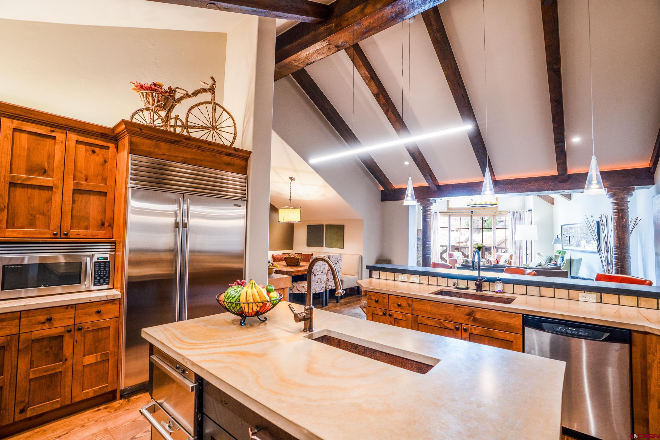 14 Hunter Hill Road, Unit A405 Crested Butte, CO 81225 - Photo 9 of 38 a kitchen with stainless steel appliances kitchen island granite countertop a sink and cabinets