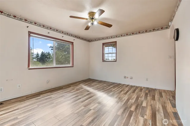 a view of empty room with wooden floor
