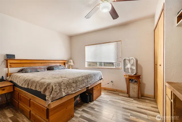 a bedroom with a bed and wooden floor