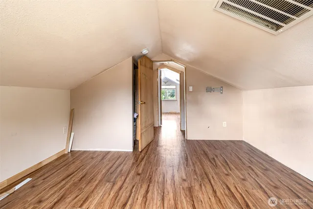 a view of a room with wooden floor and white walls
