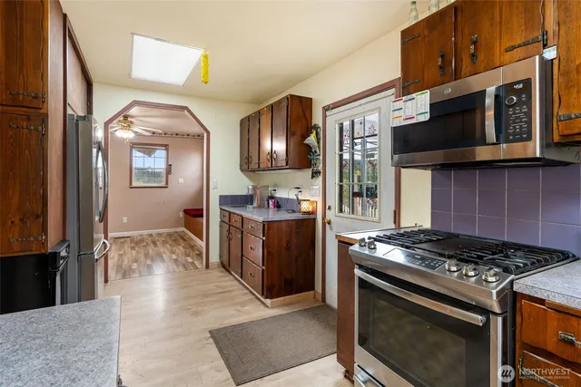 a kitchen with stainless steel appliances granite countertop a stove and a microwave