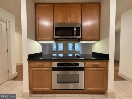 a kitchen with granite countertop a stove and a microwave