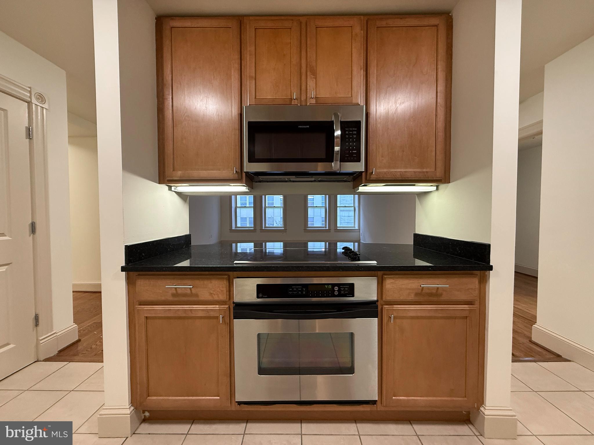 515 9th Street Northwest, Unit 3E Washington, DC 20004 - Photo 14 of 20 a kitchen with granite countertop a stove and a microwave