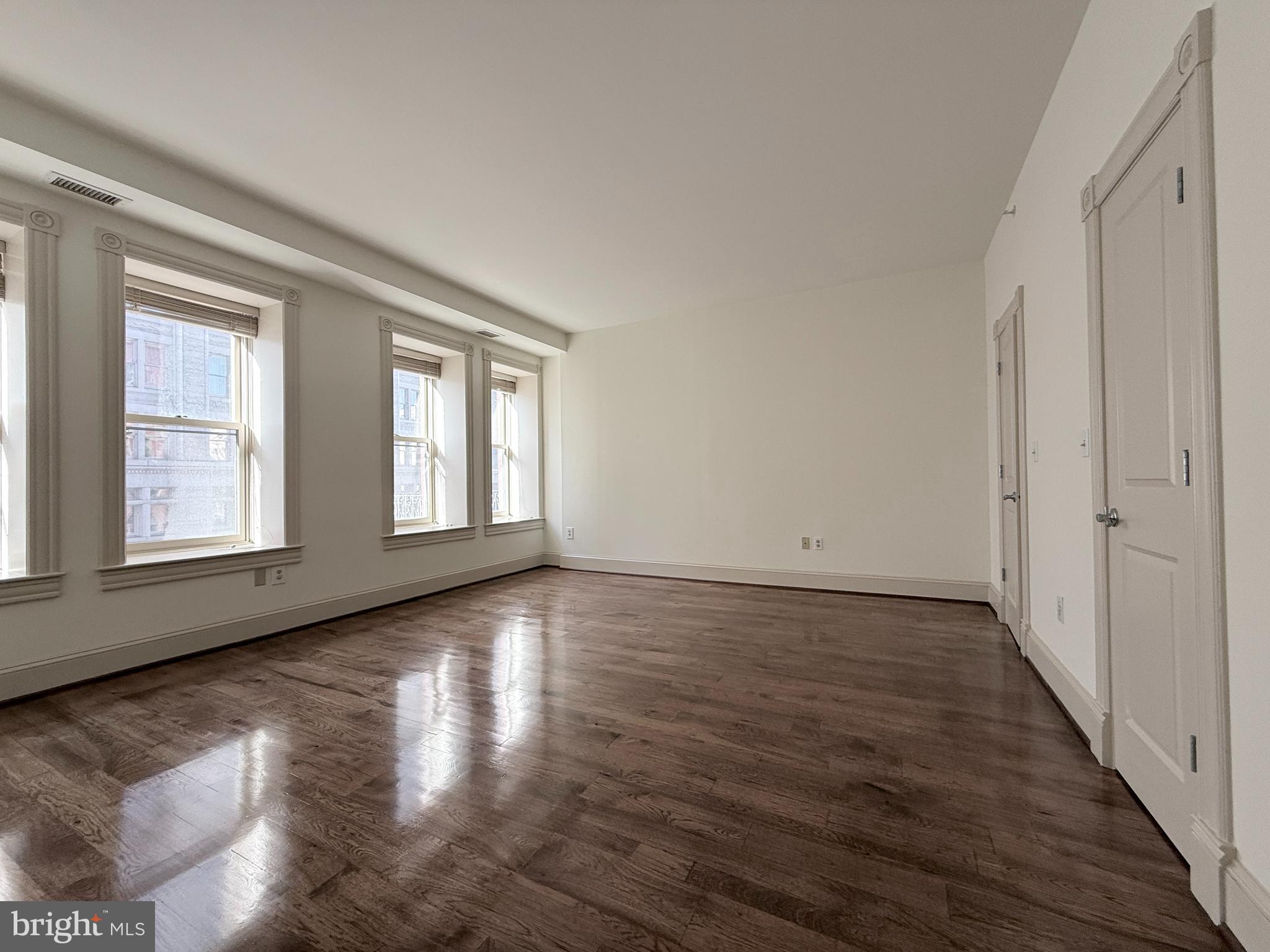 515 9th Street Northwest, Unit 3E Washington, DC 20004 - Photo 16 of 20 a view of an empty room with wooden floor and a window