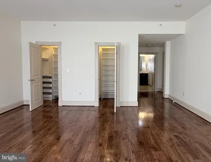 an empty room with wooden floor and closet