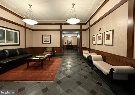 a living room with furniture a chandelier and a rug