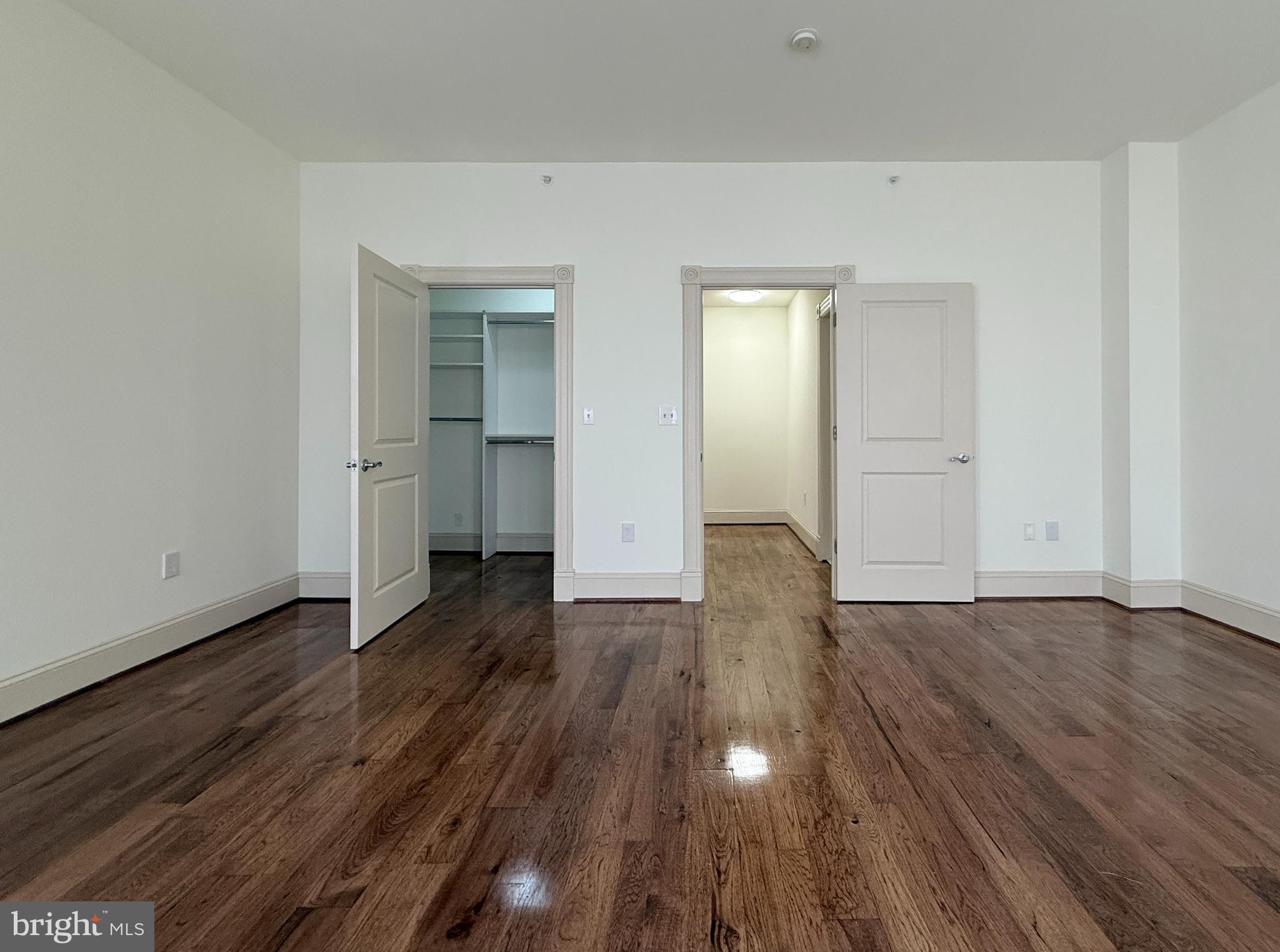 515 9th Street Northwest, Unit 3E Washington, DC 20004 - Photo 8 of 20 a view of an empty room with wooden floor and closet