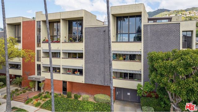 a front view of a house with plants