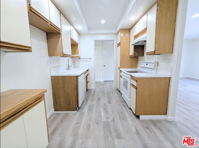 a kitchen with stainless steel appliances a stove a sink a refrigerator and a microwave