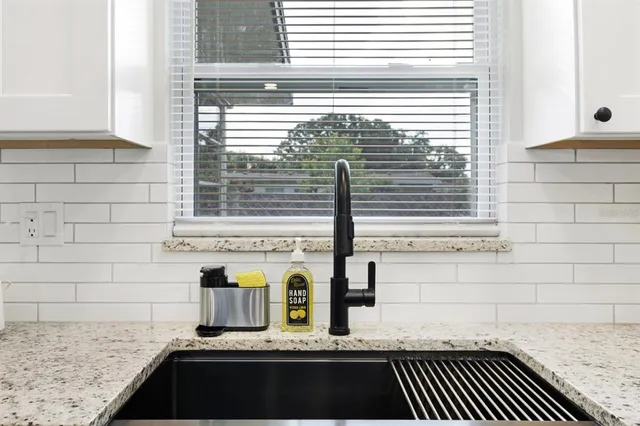 a bathroom with a granite countertop sink and a window