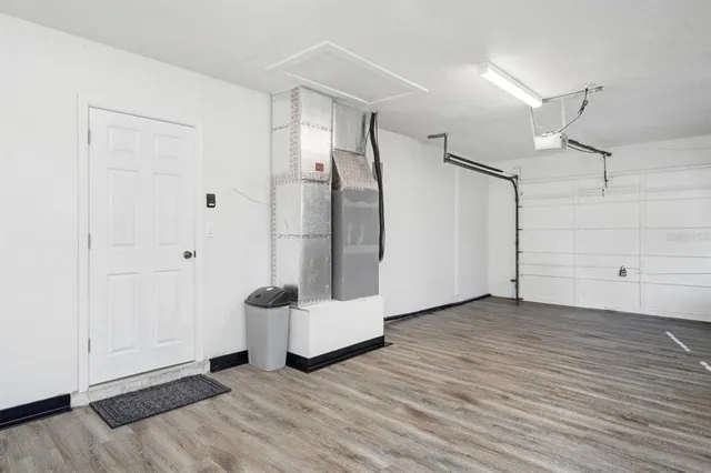 a view of an empty room with wooden floor and entryway