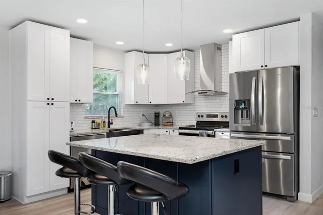 a kitchen with stainless steel appliances a sink a stove a refrigerator and cabinets