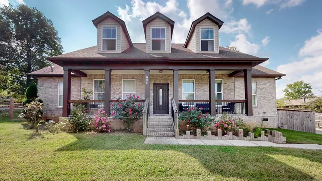 a front view of a house with porch and garden