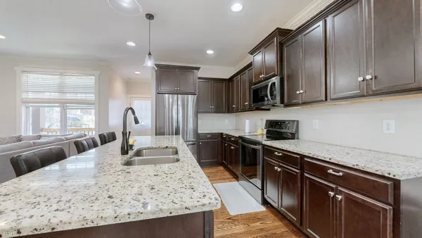 a kitchen with stainless steel appliances kitchen island granite countertop a sink stove and cabinets