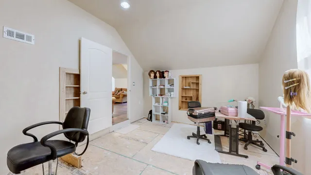 a view of a workspace with furniture and a window
