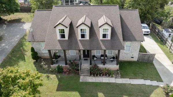 an aerial view of a house with swimming pool and a yard