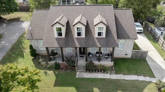 an aerial view of a house with swimming pool and a yard