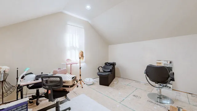 a view of a workspace with furniture and a window