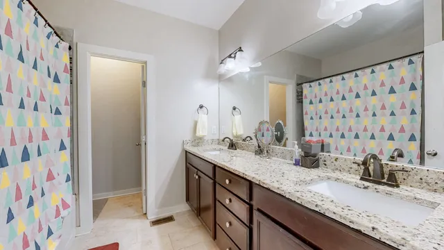 a bathroom with a granite countertop sink a mirror a vanity and a shower