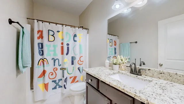 a bathroom with a sink a toilet and shower curtain