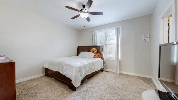 a bedroom with a bed and a ceiling fan