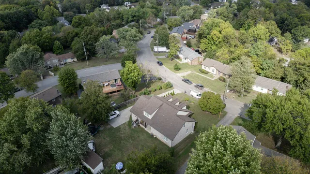 an aerial view of residential house with outdoor space and trees all around