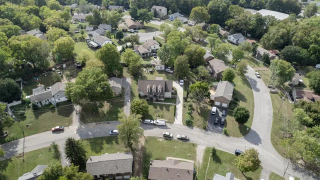 an aerial view of residential houses with outdoor space and trees