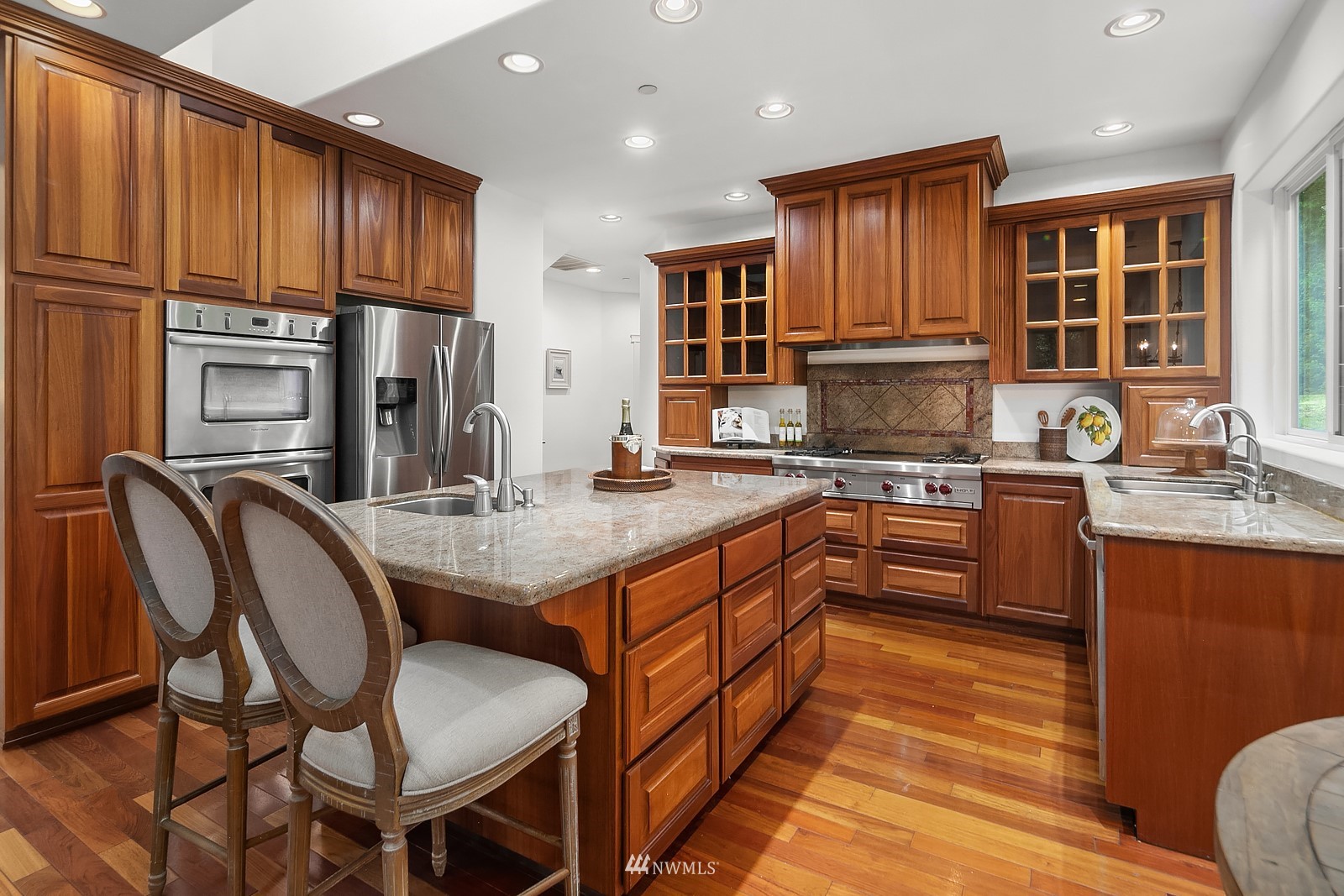 18512 Southeast Petrovitsky Road Renton, WA 98058 - Photo 12 of 40 a kitchen with stainless steel appliances granite countertop a stove top oven a sink dishwasher and cabinets with wooden floor