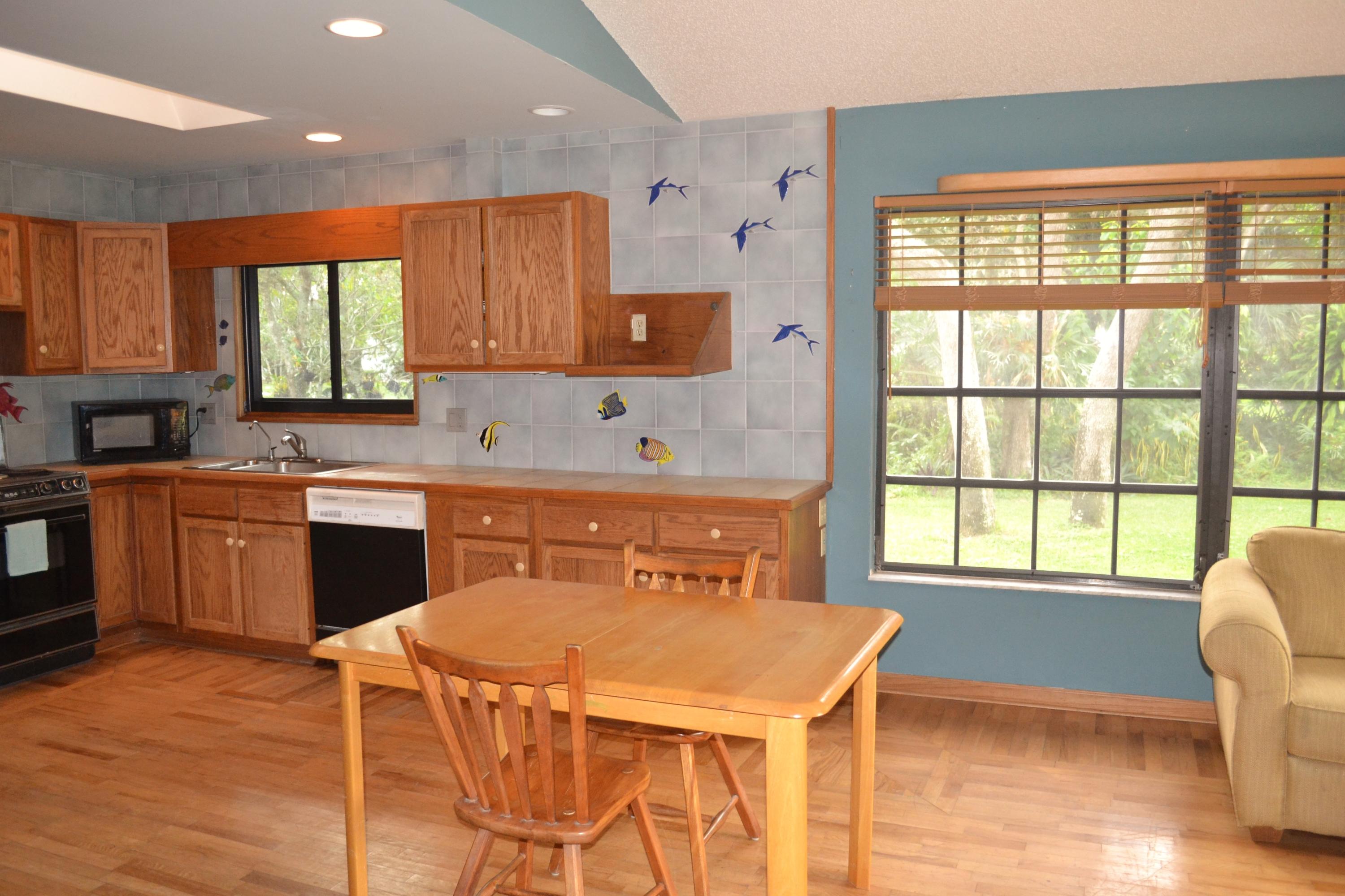 6063 Wood Lake Road Jupiter, FL 33458 - Photo 17 of 60 SKYLIGHT AND CUSTOM TILES IN KITCHEN
