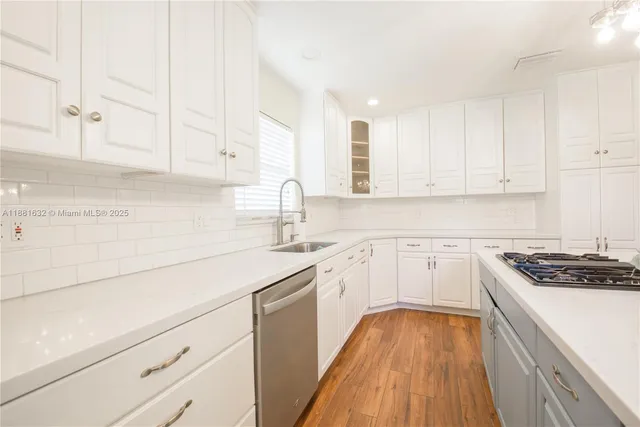 a kitchen with granite countertop white cabinets and white appliances