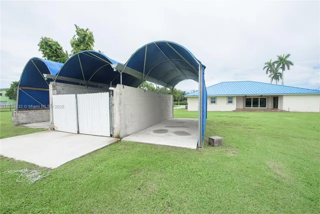 a view of a house with backyard and sitting area