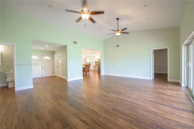 a view of a room with wooden floor and ceiling fan