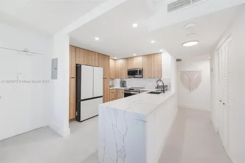 a kitchen with refrigerator a microwave and white cabinets
