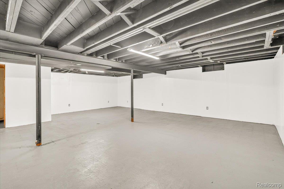 11802 Columbia Street Redford, MI 48239 - Photo 23 of 39 Expansive finished lower level featuring finished concrete flooring, drywall, and a painted exposed ceiling with overhead lighting.