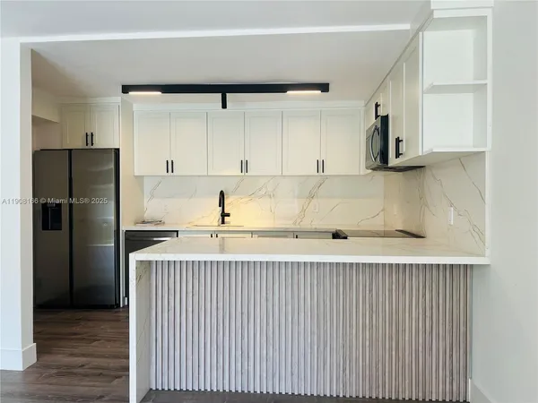 a kitchen with a refrigerator sink and cabinets
