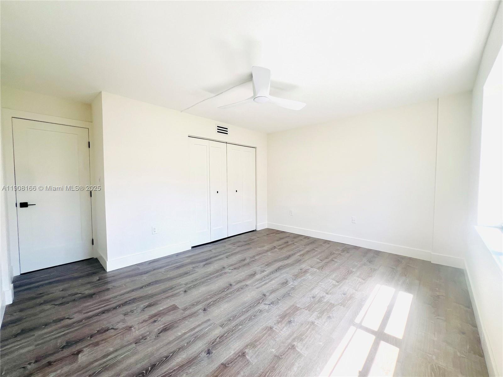 201 Jefferson Avenue, Unit 4C Miami Beach, FL 33139 - Photo 12 of 13 an empty room with wooden floor and windows