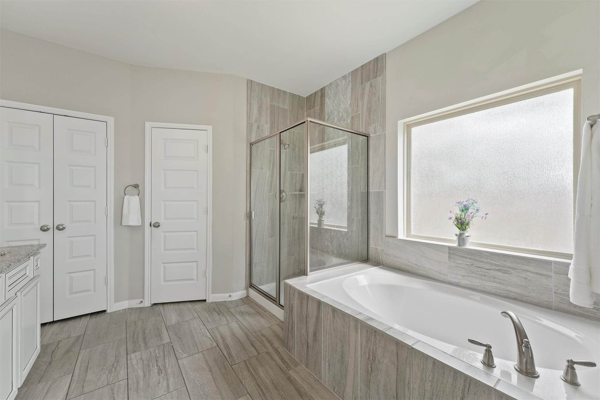 15103 Dry Ridge Court Humble, TX 77346 - Photo 18 of 28 a spacious bathroom with a granite countertop sink and a mirror