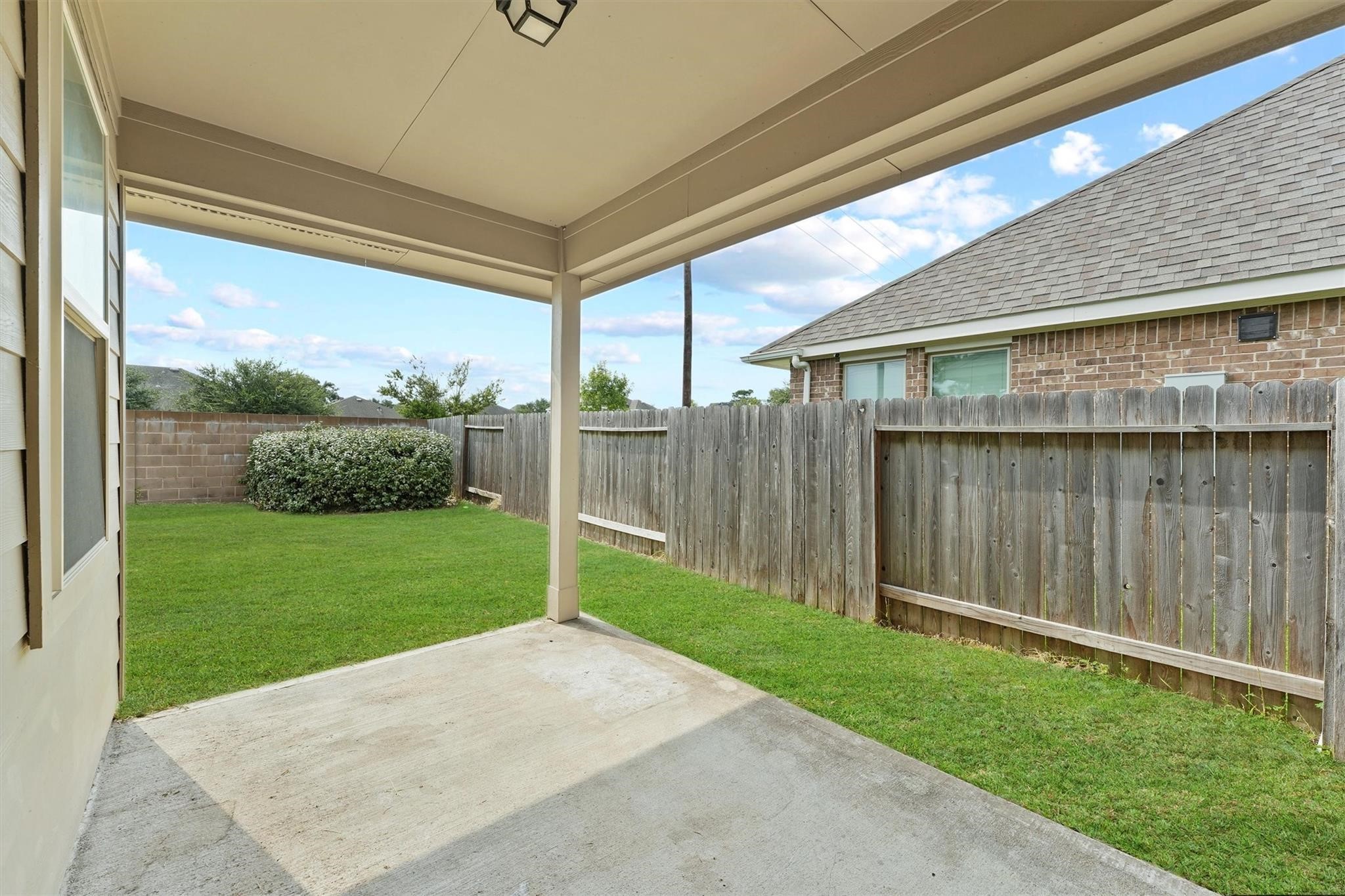 15103 Dry Ridge Court Humble, TX 77346 - Photo 20 of 28 a view of a backyard with plants and wooden fence