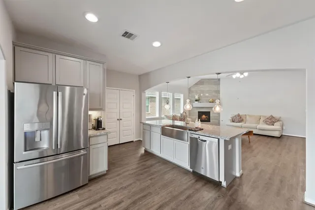 a kitchen with stainless steel appliances a refrigerator and a stove top oven